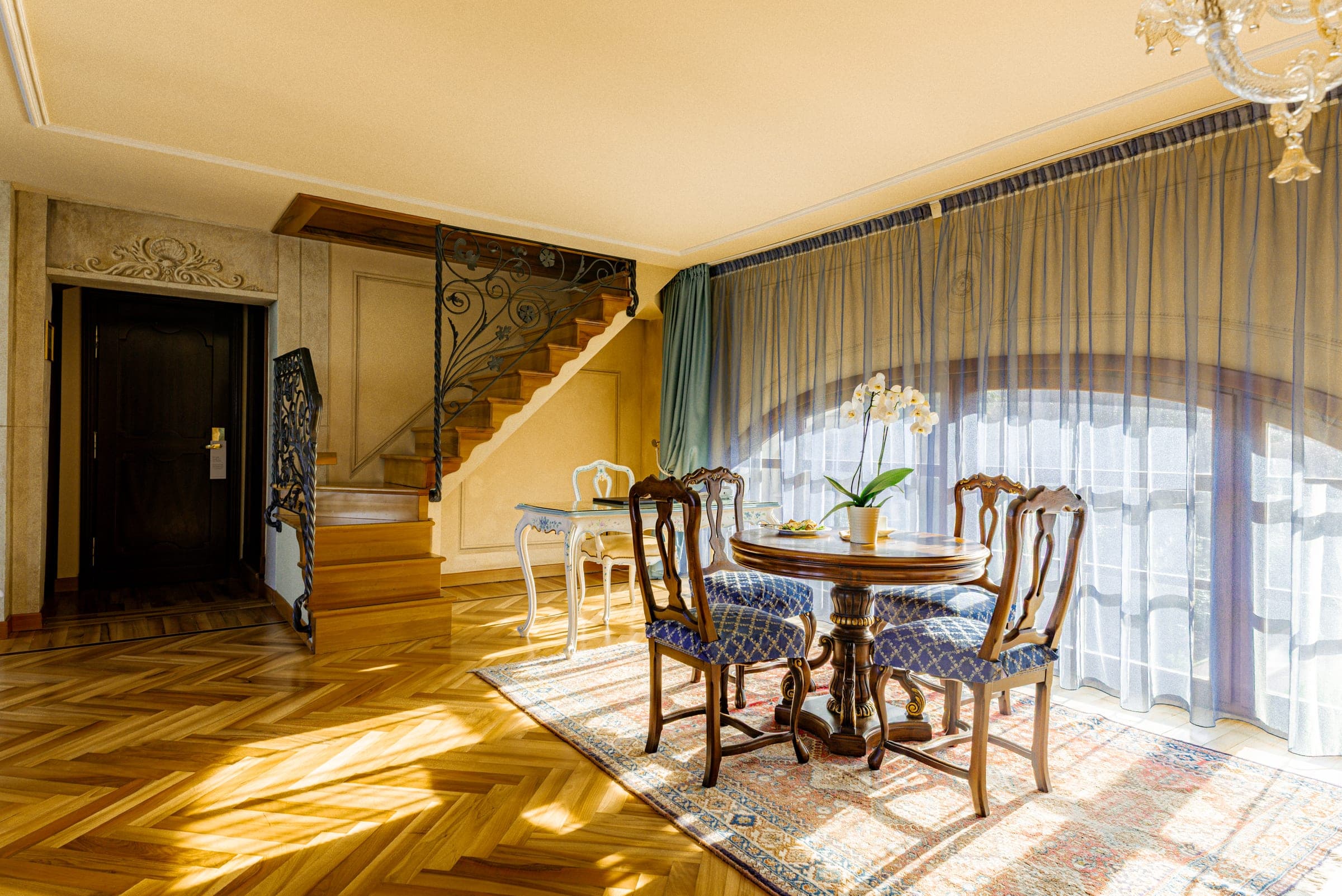 Hotel suite with grand staircase and orchid