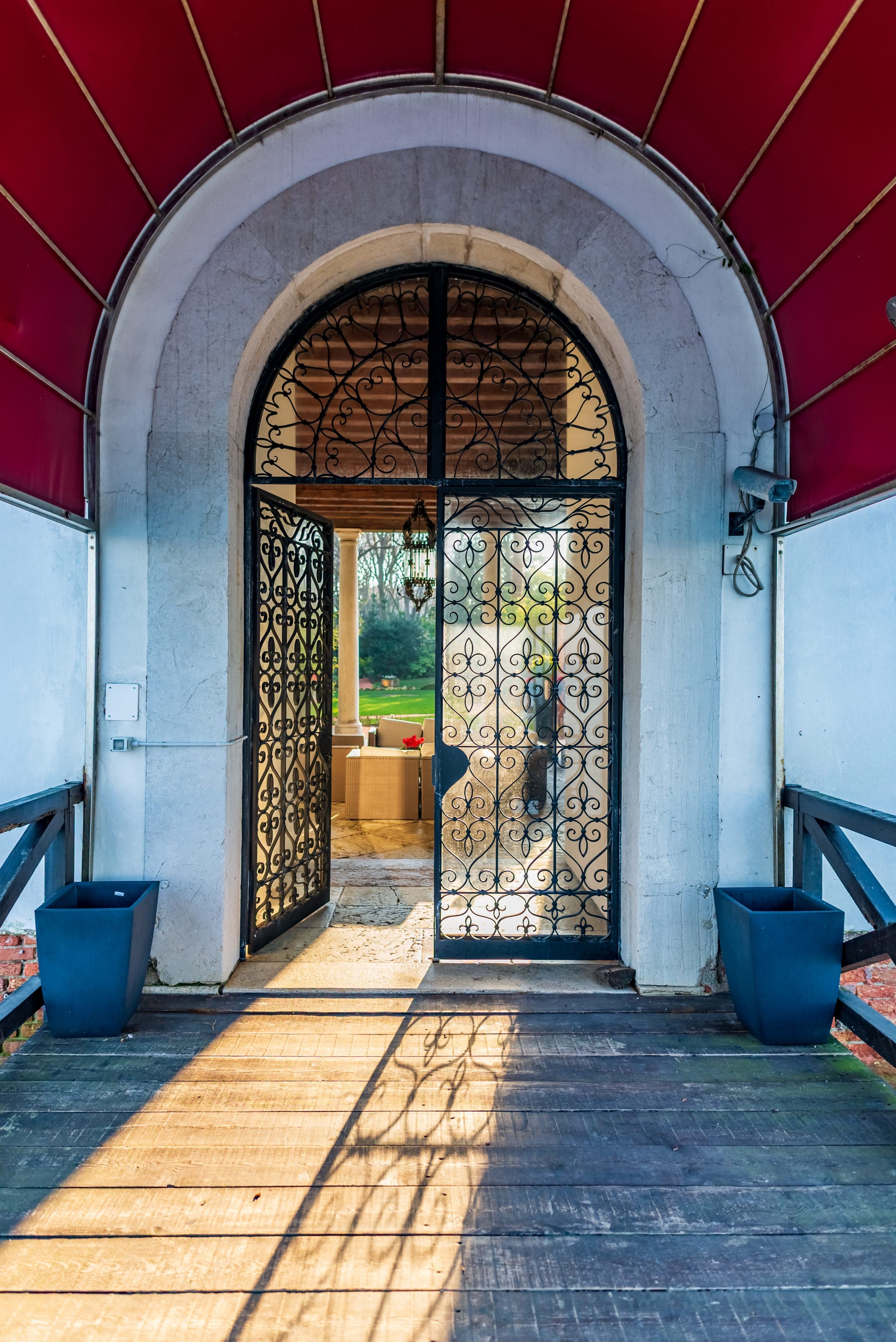 Venetian iron gate beneath red canopy