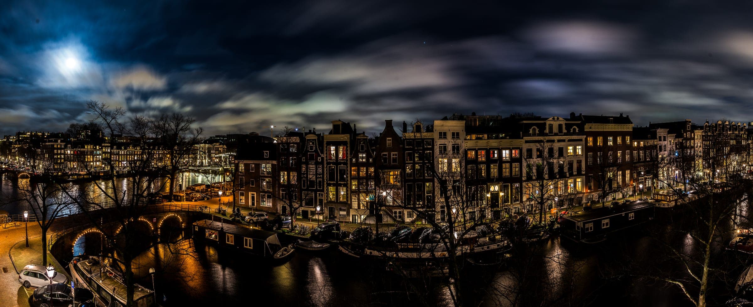 Moonlit canal panorama over Amsterdam townhouses
