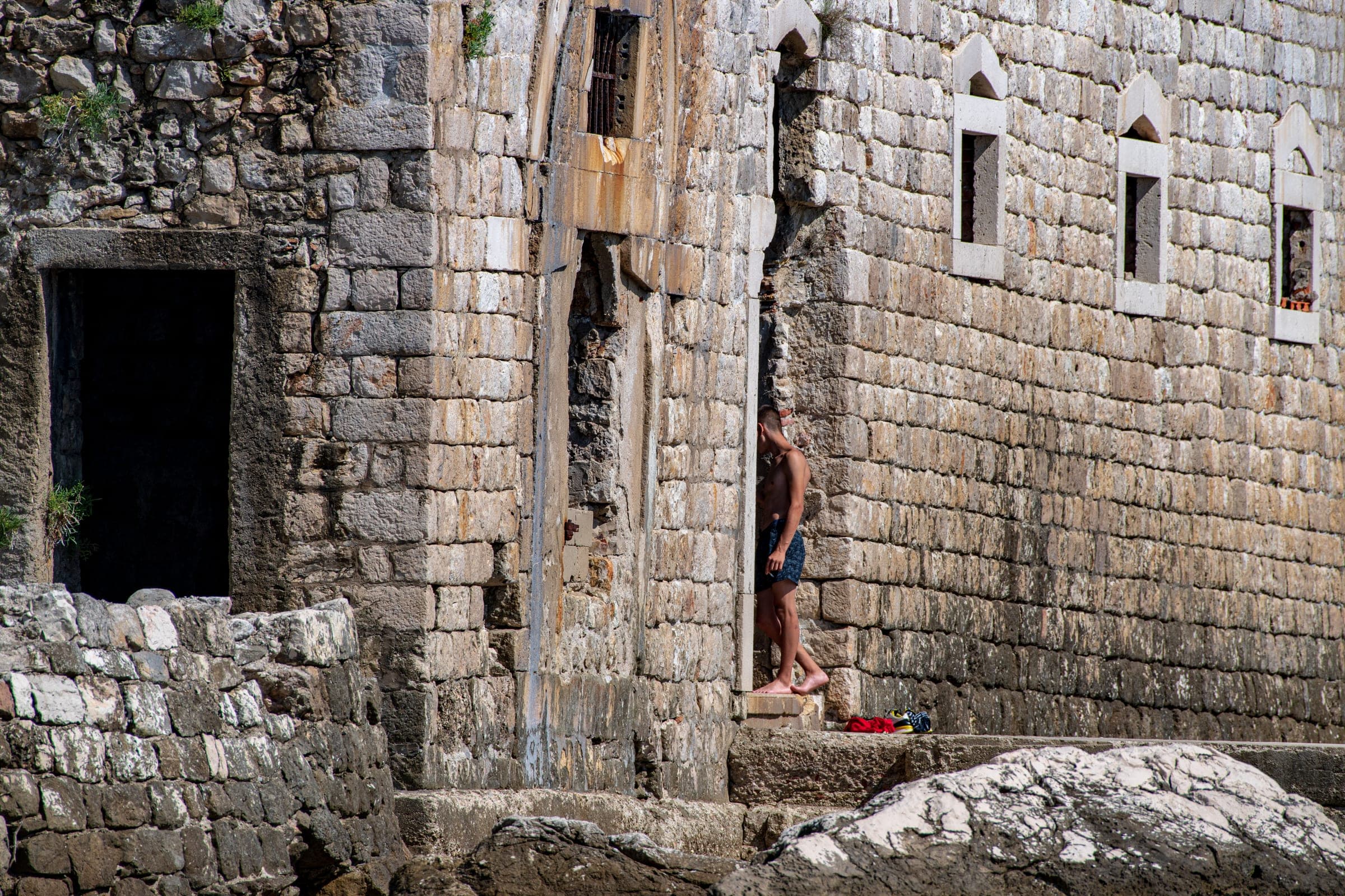 Swimmer pausing in an ancient stone alcove