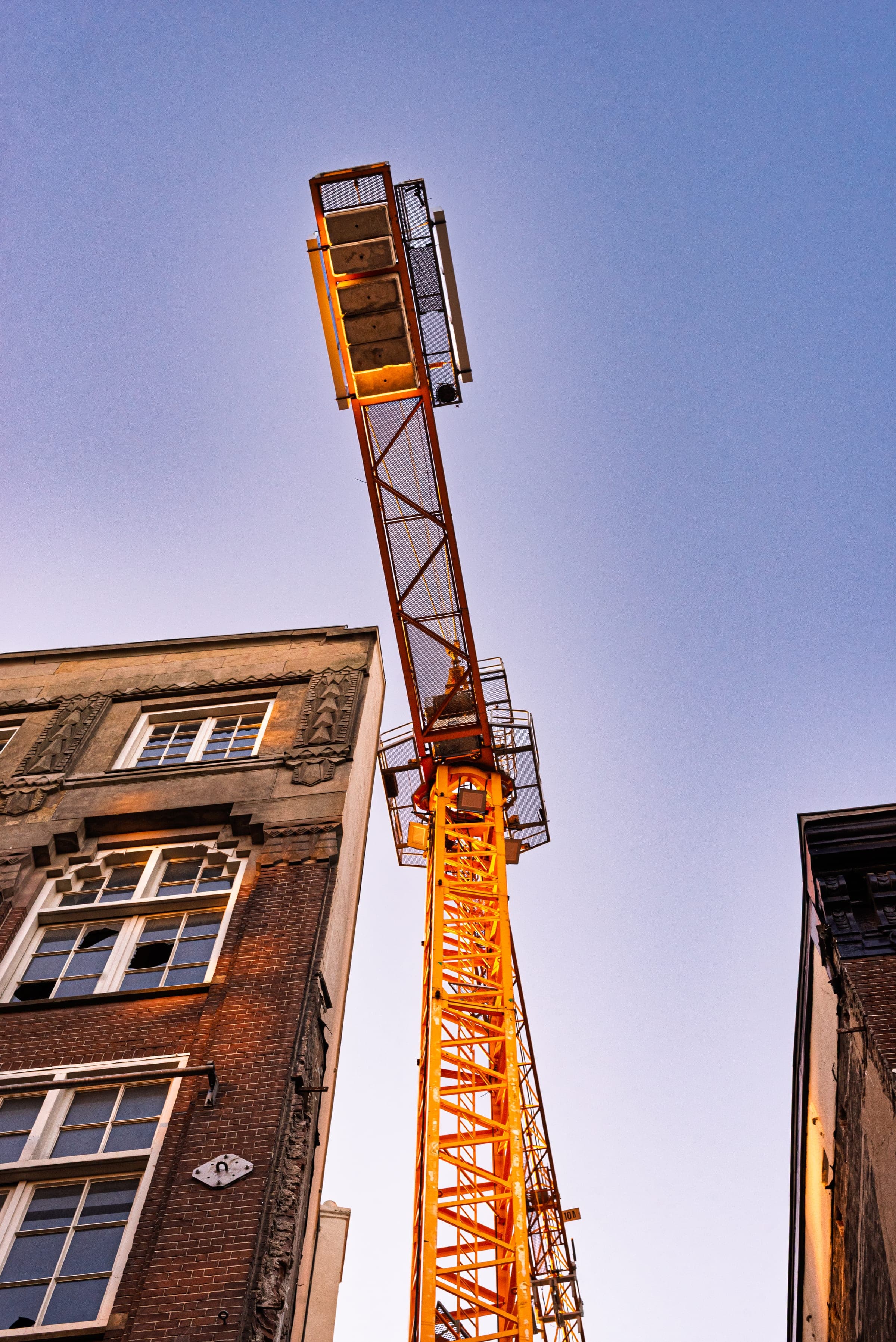 Tower crane glowing above old facades